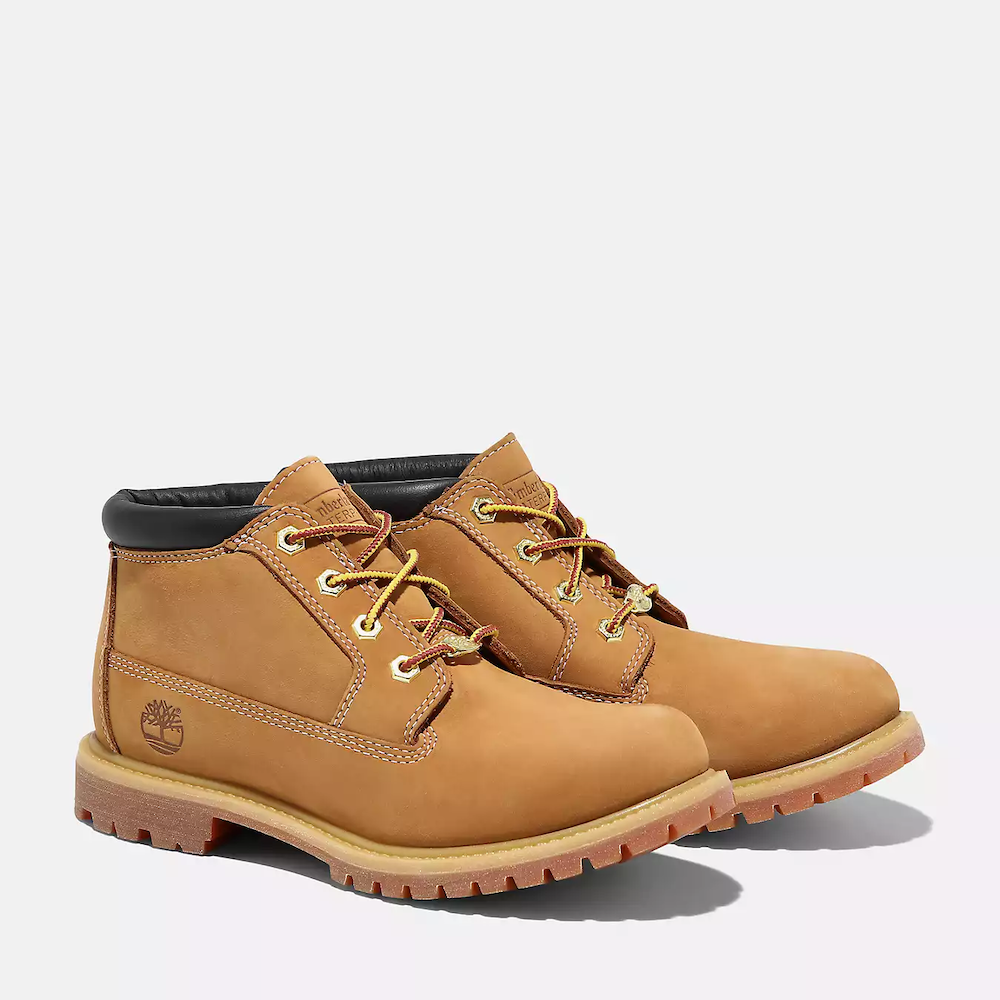 Timberland® Nellie Waterproof Chukka Boot for Women in Wheat. Wheat-colored leather chukka boot featuring waterproof construction for dry feet, padded collar for comfort, anti-fatigue technology for all-day support, and a lug outsole for traction. Pairs well with jeans, leggings, or skirts for a versatile look.