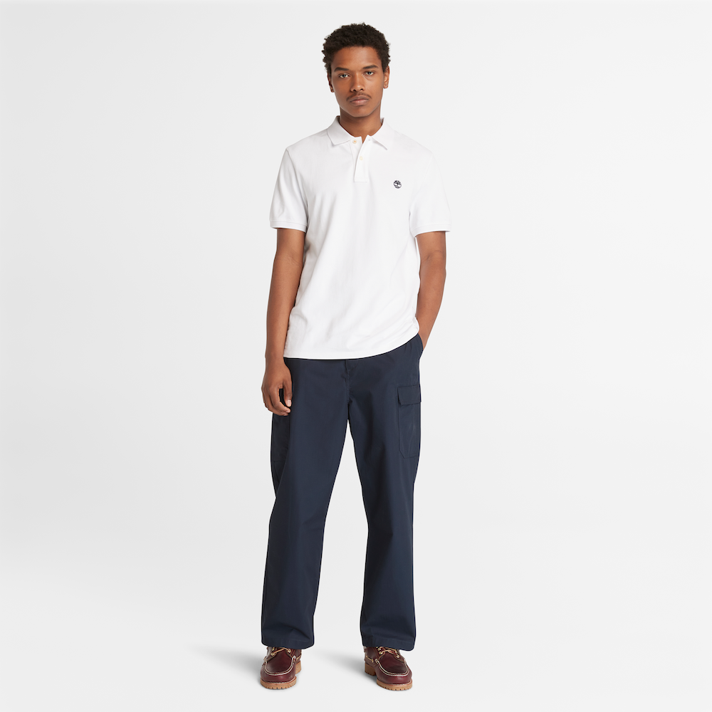 White Timberland® Millers River Pique Polo Shirt for Men. Classic white polo shirt made from 100% organically grown cotton for a comfortable and eco-conscious choice. Relaxed regular fit for comfort. Pique knit fabric for breathability. Ribbed collar and cuffs for a polished look