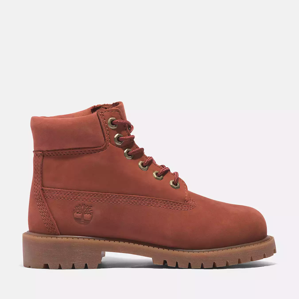 Timberland® Premium 6-Inch Lace Up Boot for Junior. Deep rust colored nubuck boot featuring waterproof construction, padded collar for comfort, signature lug sole for traction, and lace-up closure for a secure fit. Perfect for young adventurers.