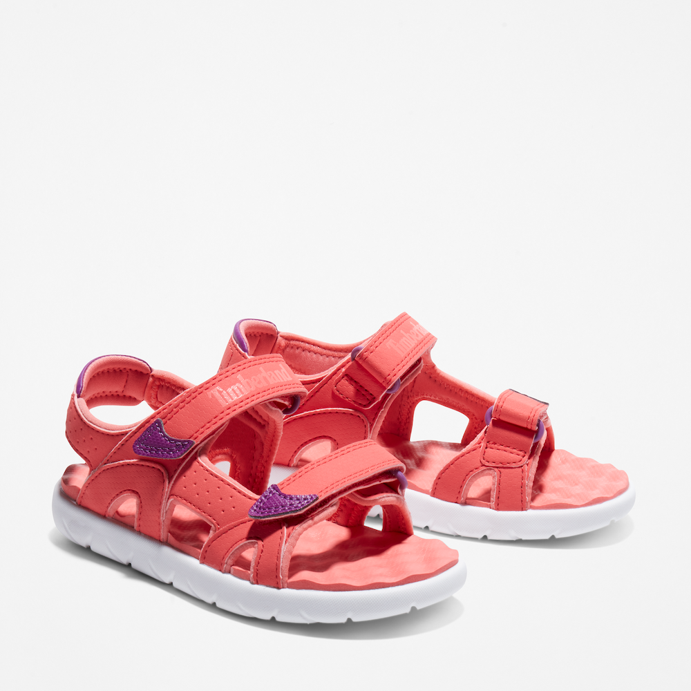 Timberland® Perkins Row 2-Strap Sandal for Junior. Bright pink sandal featuring easy hook-and-loop closure, comfortable footbed, and eco-friendly materials made with recycled plastic. Perfect for summer adventures.