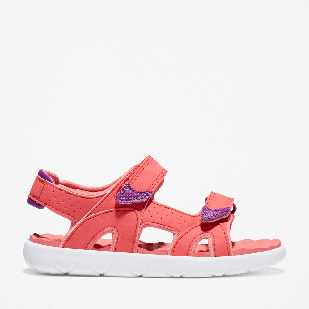 Timberland® Perkins Row 2-Strap Sandal for Junior. Bright pink sandal featuring easy hook-and-loop closure, comfortable footbed, and eco-friendly materials made with recycled plastic. Perfect for summer adventures.