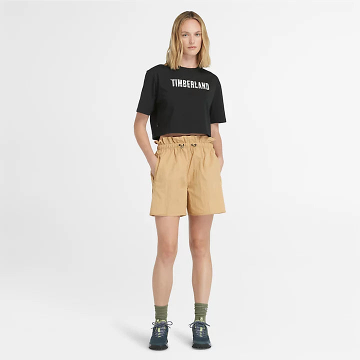 Black Timberland® Cropped Short Sleeve Tee for Women. Soft, breathable 100% cotton. Relaxed fit for comfort. Cropped silhouette for a trendy look. Ribbed collar for a snug fit. Iridescent graphic print for eye-catching style.