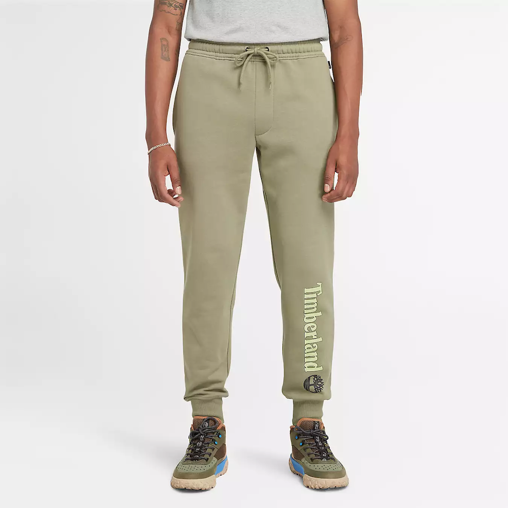 Green Timberland® Kennebec River Linear Logo Sweatpant for Men. Soft cotton blend fabric (85% cotton, 15% polyester) for comfort and breathability. Relaxed fit for comfortable wear. Elasticated drawcord waistband for customisable fit. Side pockets for storage.