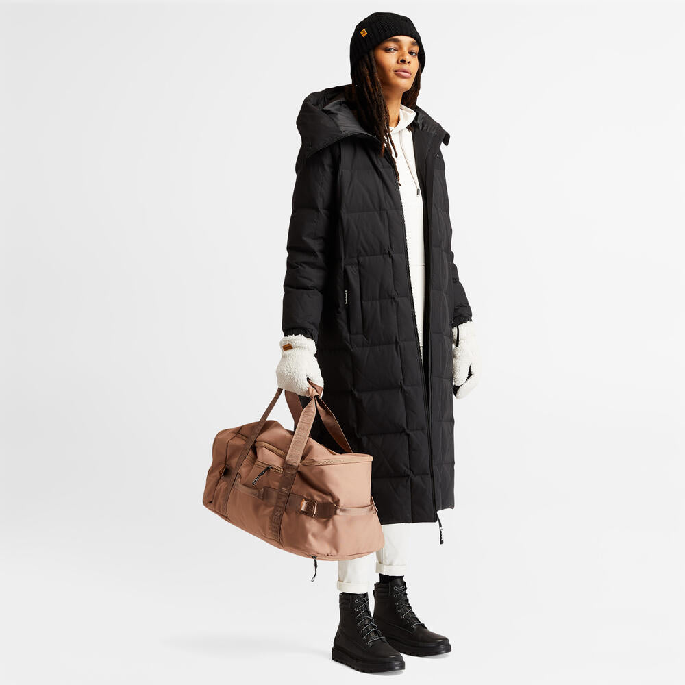 Black Timberland Cable Knit Pom Pom Beanie for Women. Soft and chunky cable knit for warmth and texture. Fold-over cuff for adjustability. Fluffy pom pom for a playful touch. Classic black color for versatility.