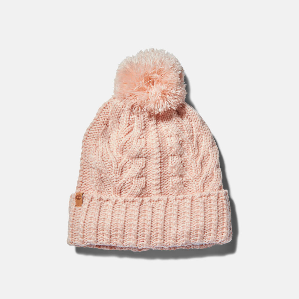 Rose Timberland Cable Knit Pom Pom Beanie for Women. Soft and chunky cable knit for warmth and texture. Fold-over cuff for adjustability. Fluffy pom pom for a playful touch. Rose colour for femininity.