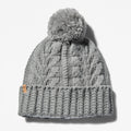 Grey TimberlandÂ® Cable Knit Pom Pom Beanie for Women. Soft and chunky cable knit for warmth and texture. Fold-over cuff for adjustability. Fluffy pom pom for a playful touch. Grey color for versatility.