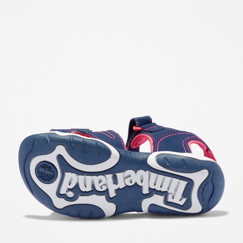 Timberland Adventure Seeker Sandal for Junior. Dark blue sandal with pink detailing, featuring adjustable straps and a comfortable footbed. Perfect for outdoor adventures.