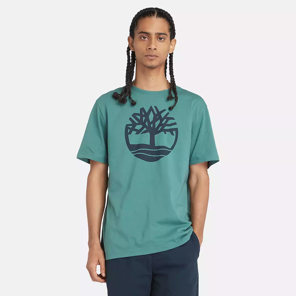 Teal Timberland® Kennebec River Tree Logo T-Shirt for Men. Soft cotton for comfort and breathability. Classic crew neck design. Short sleeves for ventilation. Timberland® tree logo on chest. Vibrant teal color for a pop of style. 