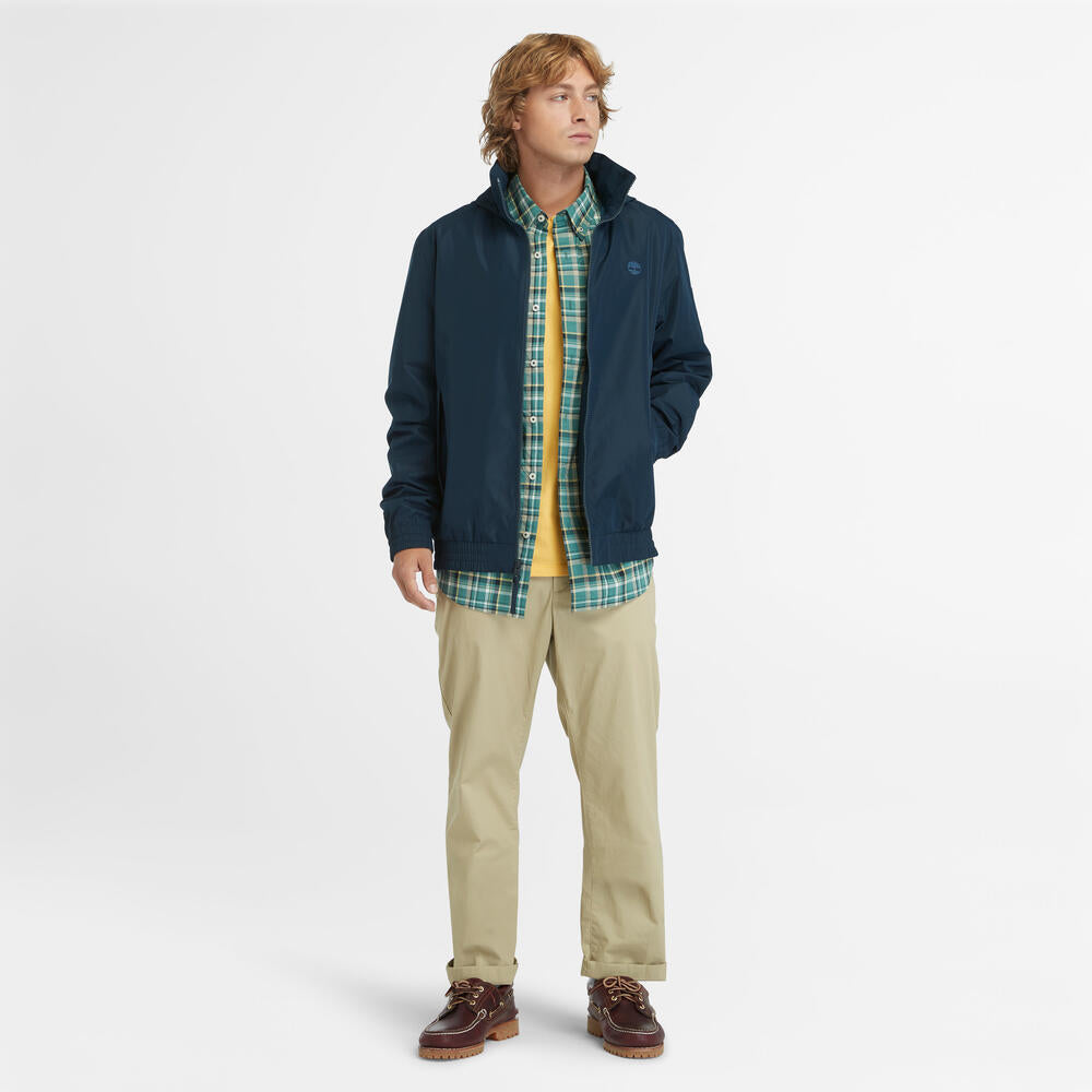Navy Timberland¡ Water Resistant Bomber Jacket for Men. Water-resistant fabric repels moisture. Durable construction for long-lasting wear. Regular fit for comfort. Ribbed cuffs and hem for a snug fit. Button-up front closure. Side pockets and utility sleeve pocket. Classic navy color for versatility.