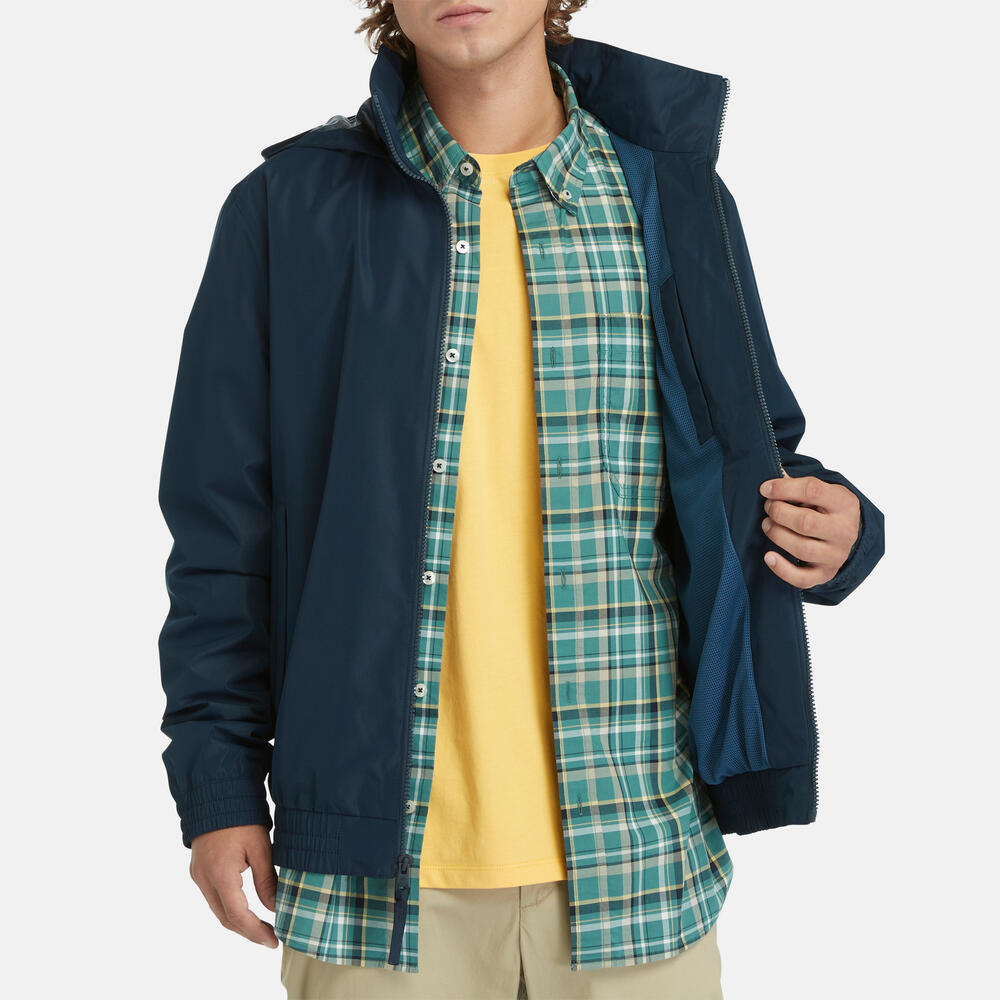 Navy Timberland¡ Water Resistant Bomber Jacket for Men. Water-resistant fabric repels moisture. Durable construction for long-lasting wear. Regular fit for comfort. Ribbed cuffs and hem for a snug fit. Button-up front closure. Side pockets and utility sleeve pocket. Classic navy color for versatility.