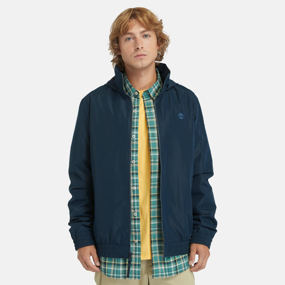 Navy Timberland® Water Resistant Bomber Jacket for Men. Water-resistant fabric repels moisture. Durable construction for long-lasting wear. Regular fit for comfort. Ribbed cuffs and hem for a snug fit. Button-up front closure. Side pockets and utility sleeve pocket. Classic navy color for versatility.