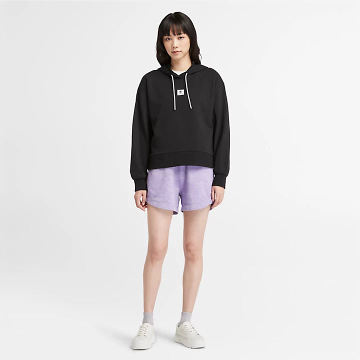 Black Timberland Women's Loopback Hoodie. Made with 80% cotton for softness and breathability. Dropped-shoulder silhouette for a relaxed, modern look. Drawcord-adjustable hood for warmth and coverage