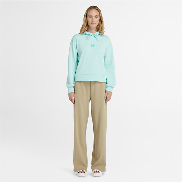 Light blue Timberland Women's Loopback Hoodie. Made with 80% cotton for softness and breathability. Dropped-shoulder silhouette for a relaxed look. Drawcord-adjustable hood for warmth and coverage.