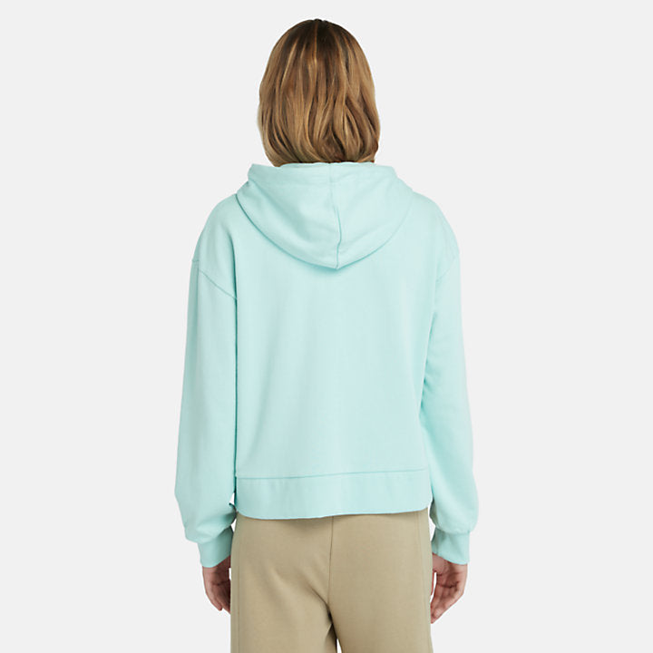 Light blue Timberland Women's Loopback Hoodie. Made with 80% cotton for softness and breathability. Dropped-shoulder silhouette for a relaxed look. Drawcord-adjustable hood for warmth and coverage.