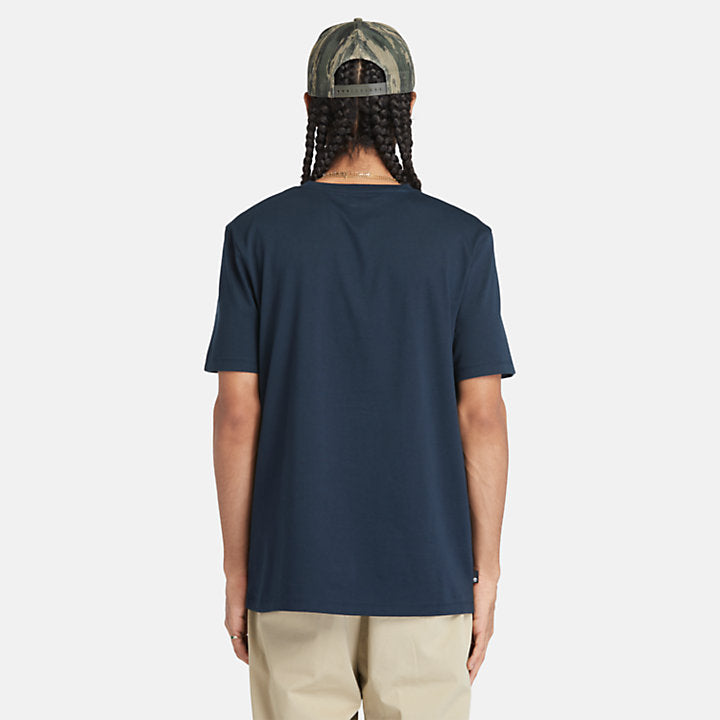 Navy Timberland® Kennebec River Linear Logo Tee. 100% cotton for softness and breathability. Crew neck, relaxed fit, short sleeves. Logo print for heritage style. Pairs well with casual pants.