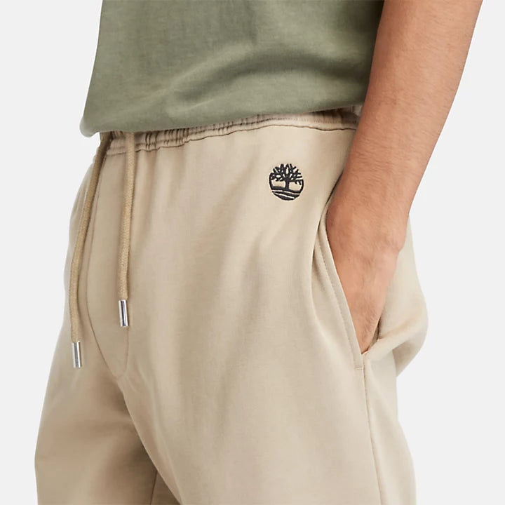 Timberland® Loopback Sweatpants for Men. Grey sweatpants featuring a relaxed fit with a mid-rise, tapered leg, and ribbed ankle cuffs. Made from a soft knit fabric with 82% cotton and 18% polyester (including 82% organically grown cotton).  Includes handy side pockets, an elasticated drawcord waistband, and an embroidered logo for a touch of style. Perfect for everyday wear.