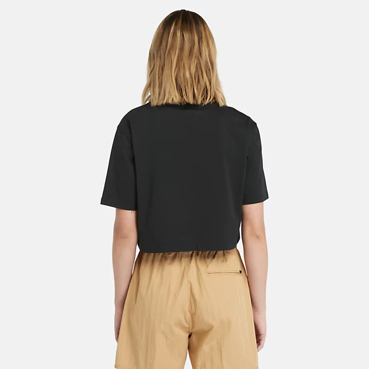 Black Timberland® Cropped Short Sleeve Tee for Women. Soft, breathable 100% cotton. Relaxed fit for comfort. Cropped silhouette for a trendy look. Ribbed collar for a snug fit. Iridescent graphic print for eye-catching style.