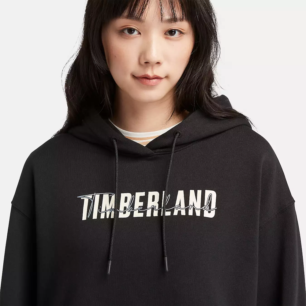 Black Timberland® Brushed Back Logo Hoodie for Women. Soft, breathable cotton blend with brushed-back fleece for warmth. Relaxed fit, cropped silhouette (18.0" center back length). Adjustable hood for warmth and coverage. Ribbed cuffs and hem for a snug fit