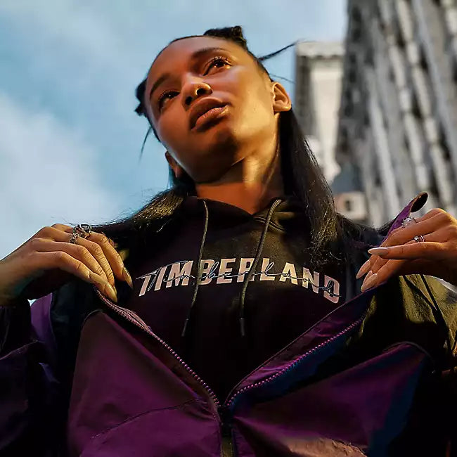 Black Timberland Brushed Back Logo Hoodie for Women. Soft, breathable cotton blend with brushed-back fleece for warmth. Relaxed fit, cropped silhouette (18.0" center back length). Adjustable hood for warmth and coverage. Ribbed cuffs and hem for a snug fit