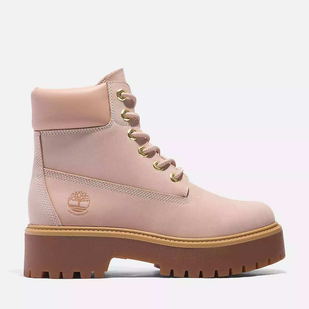 Light pink Timberland® Women's Stone Street 6-Inch Platform Waterproof Boot. Light pink leather boot featuring a platform sole for added height and a classic 6-inch silhouette.  Crafted with waterproof premium leather for dry feet and featuring seam-sealed construction for additional protection.  Lined with ReBOTL™ fabric containing at least 50% recycled plastic for an eco-conscious touch.  Features a padded collar for comfort, a lace-up closure for a secure fit, and a lug outsole for reliable traction. 