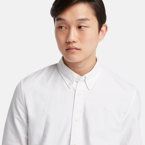 Timberland‚® Long Sleeve Oxford Shirt for Men in White. White oxford shirt featuring a relaxed regular fit for comfortable wear. Made from 100% organic cotton for a soft and breathable feel. Features a mini button-down collar, rounded cuffs, and faux shell buttons for a polished look.  Timberland‚® tree logo embroidered on the chest for subtle branding. Pairs well with jeans, chinos, or dress pants for work, casual outings, or layered looks.