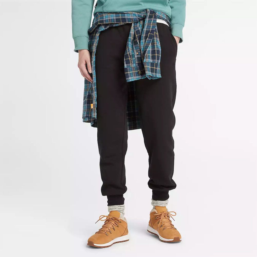 Black Timberland Brushed Back Joggers for Women. Black sweatpants featuring a soft, brushed-back fabric for warmth and comfort.  These joggers offer a relaxed fit with an elasticated drawstring waistband, cuffed ankles, and two handy side pockets