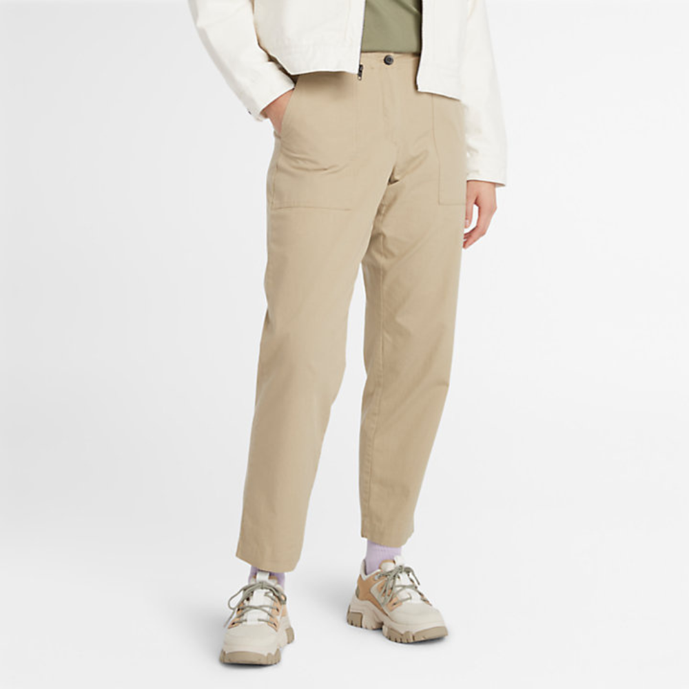 Timberland Utility Fatigue Trousers For Women In BeigeBeige Timberland® Utility Fatigue Trousers for Women. Organic cotton and elastane blend for comfort and stretch. Tapered fit. Cargo pocket with flap and side pockets for storage. Button and fly closure. Drawstring hem for adjustability.